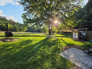 Un espace extérieur verdoyant, doté d’un barbecue, de tables de pique-nique et d’un coin salon abrité.