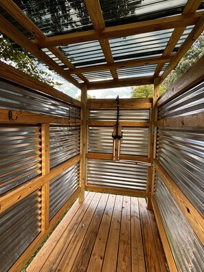 Una struttura in legno con tetto in metallo e pavimento di legno.