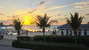 A resort with a pool area, palm trees, and a sunset view. - "Serenity" at the Infiniti Pool - Oceanview 2/2 at Resorts World Bimini Bay (Bimini)