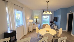 A dining area with a round table, white chairs, and a ceiling fan. - "Serenity" at the Infiniti Pool - Oceanview 2/2 at Resorts World Bimini Bay (Bimini)