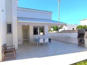 A modern house with a covered patio, a barbecue area, and a small seating area with tables and chairs. - Villa Solento (Crab House): with all the comforts just a stone's throw from the sea. (Campomarino)