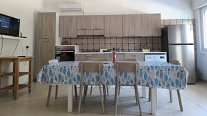 Una cocina moderna con armarios de madera, estufa a gas, horno empotrado y refrigerador de acero inoxidable.