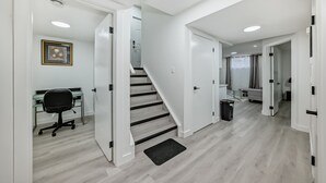 A modern interior with a staircase, a desk, and a trash bin. - Rome Sweet Home 2. Private Guest Suite in a quiet, family-friendly neighborhood. (Calgary)