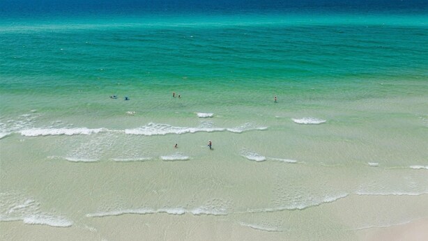 Een strand met helder turquoise water en een zandstrand.