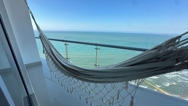 A hammock on a balcony overlooking the ocean. - Charming 2-bedroom apartment in front of the Beach with WiFi, AC, Pool, Jacuzzi (Cartagena de Indias)