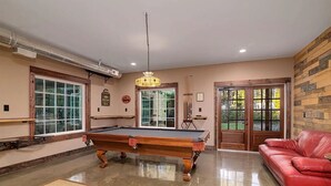 A billiards room with a pool table, a red leather sofa, and a wooden wall. - Charming 2-bedroom barn with WiFi, AC in awesome Midland (Midland)