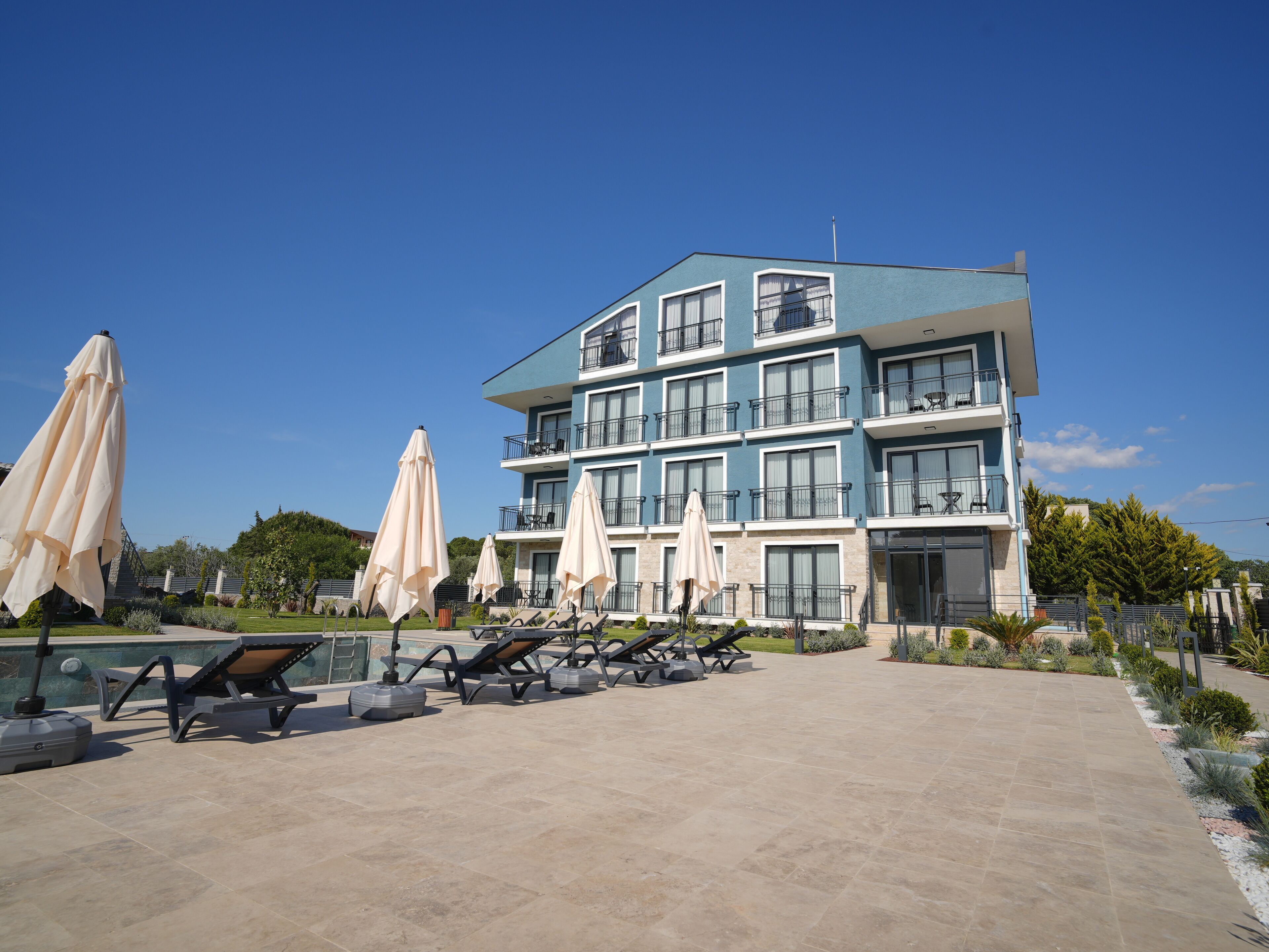 Een meerlaags hotel met terras en een zwembad.