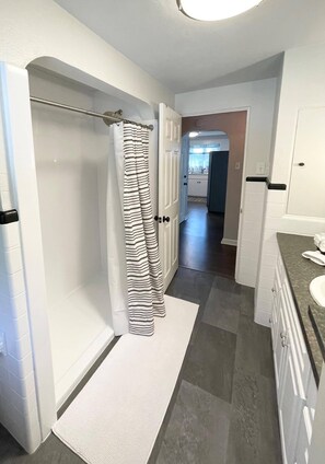 Enjoy a refreshing shower in this clean bathroom with a walk-in shower and modern sink.