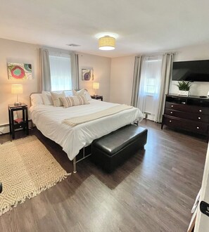 Relax in comfort with a large bed and matching bench, a flat-screen TV, and a dresser with drawers.