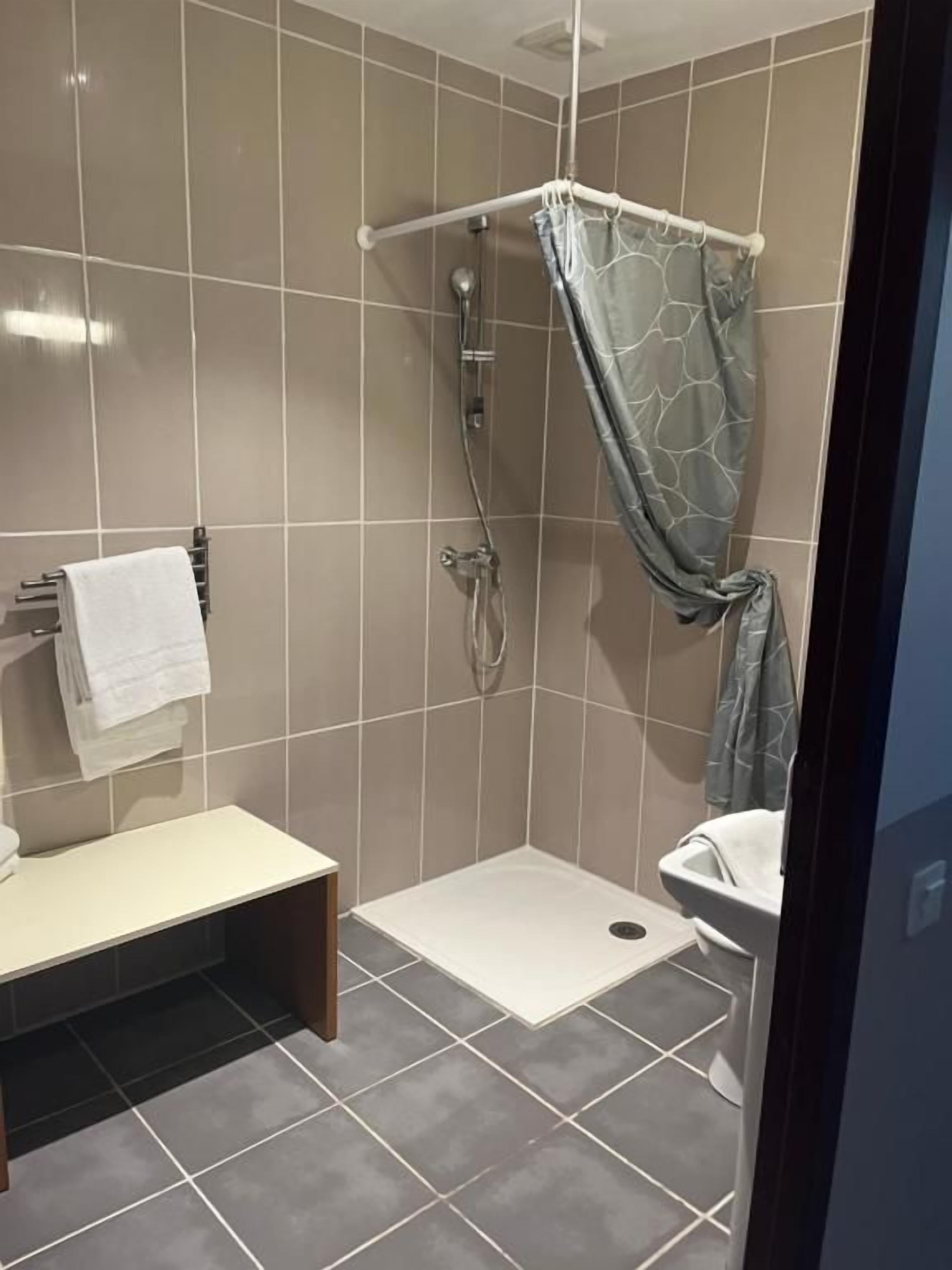 A bathroom with a shower, toilet, and sink.