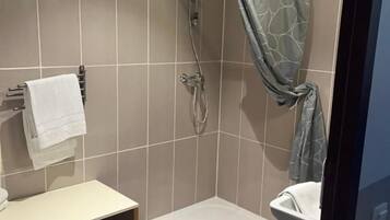 A bathroom with a shower, toilet, and sink.