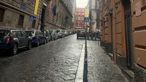 A narrow cobblestone street lined with historic buildings, some with balconies and flags. - ar.b&b nel cuore di napoli (Naples)