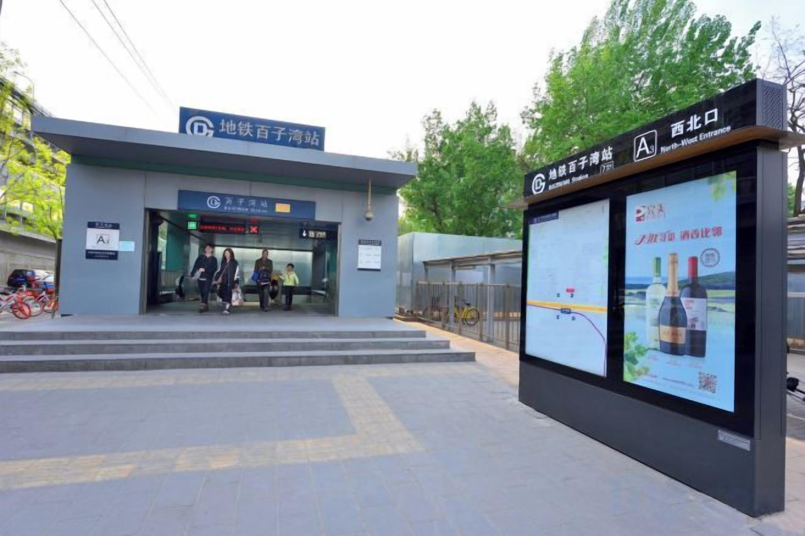 A building entrance with a sign for a hotel and a digital advertisement display.