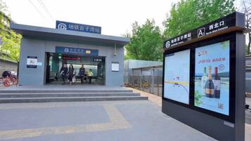 A building entrance with a sign for a hotel and a digital advertisement display.
