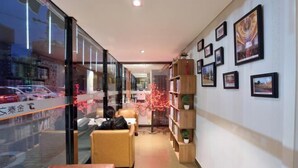 A modern interior with a seating area, bookshelves, and framed pictures on the walls. - Golden Inns (Beijing Dajiaoting) (Beijing)