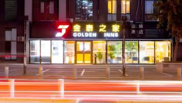 A hotel named 'Golden Inns' with a prominent sign, a well-lit entrance, and a clear view of the building's facade.