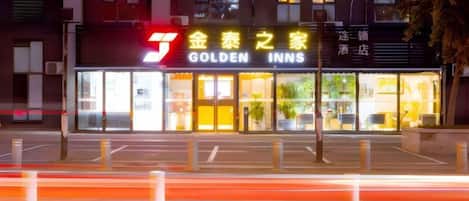 A hotel named 'Golden Inns' with a prominent sign, a well-lit entrance, and a clear view of the building's facade.