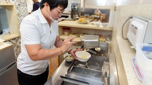 Une personne préparant des aliments sur un comptoir équipé de divers appareils et ustensiles de cuisine.