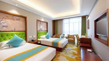 A hotel room with two beds, a desk, a chair, and a television.