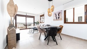 Un comedor moderno con una mesa redonda, sillas y un amplio ventanal con vistas.