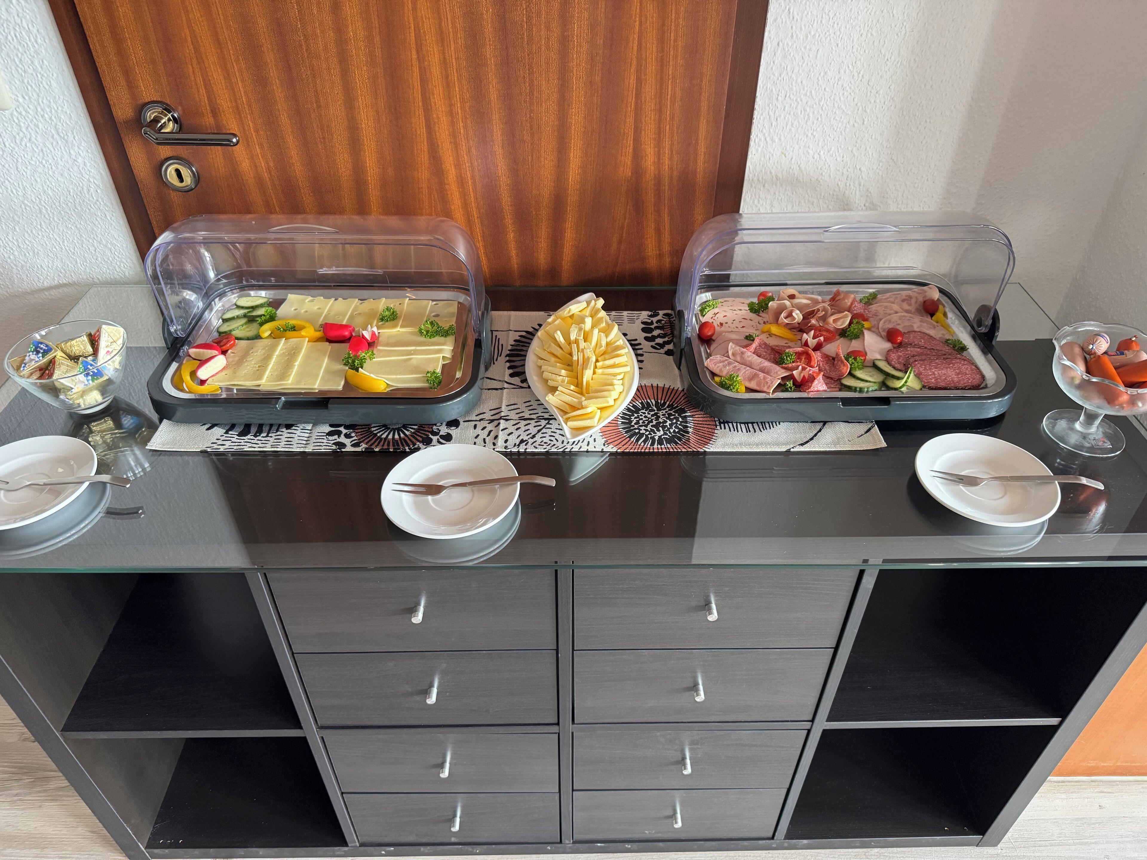A buffet table with various food items and utensils.