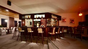 A bar area with wooden chairs and a bar counter. - Barbarossa Hotel Kelbra (Kelbra)