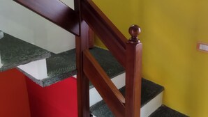 Un escalier avec des rampes en bois et un mur jaune.
