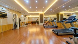 A gym with treadmills, stationary bikes, and weight machines. - Dahe Jinjiang Hotel (Zhengzhou)