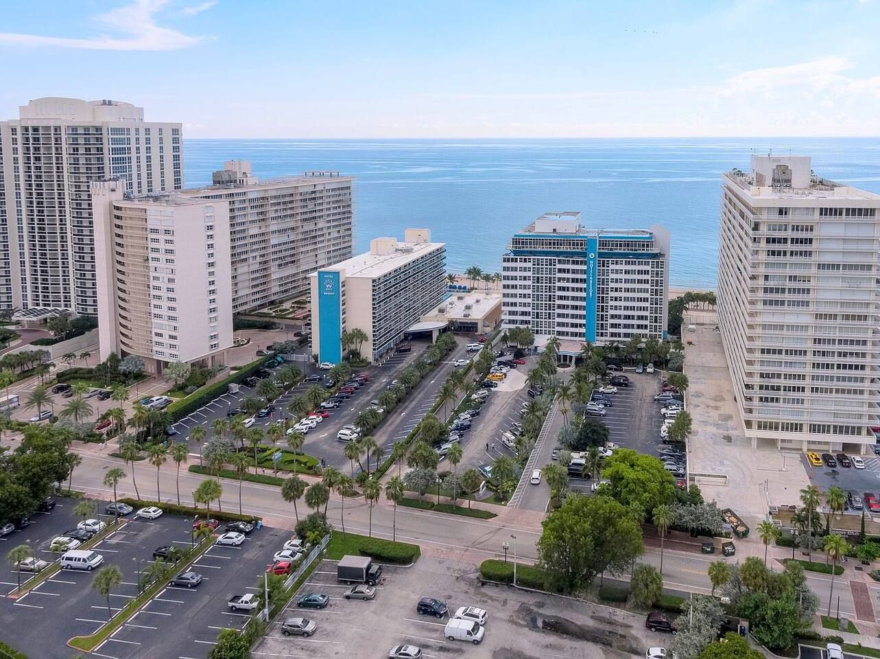 Um complexo de edifícios altos com vários estacionamentos e vista para o oceano.