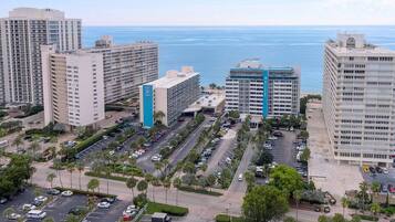 Um complexo de edifícios altos com vários estacionamentos e vista para o oceano.