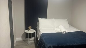 A bedroom with a bed, a bedside table, a ceiling fan, and a door. - PROMO NOW: City and Stadium Sanctuary Vibes (Orlando)