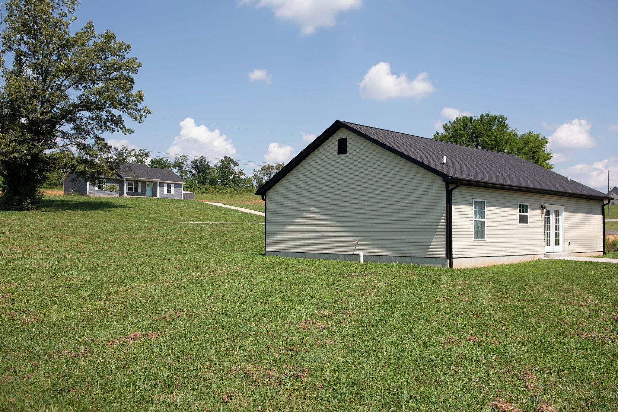 A single-story building with a gabled roof, a front door, and a small porch.