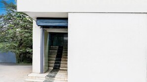 A white building with a staircase leading to a door.