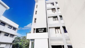 A modern hotel building with a prominent sign reading "HOTEL O & Company-Service".