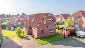 Un modelo de una zona residencial con casas, un camino de entrada y un cobertizo pequeño.