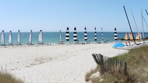 Una playa con veleros alineados en la arena.