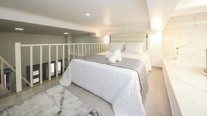 A modern bedroom with a bed, a white railing, and a marble countertop.