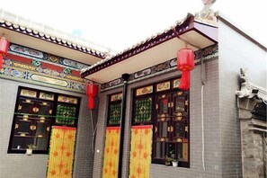 A traditional building with ornate decorations, a tiled roof, and red lanterns. - Ju Yuan Ge Inn (Pingyao Ancient City North Gate) (Pingyao County)