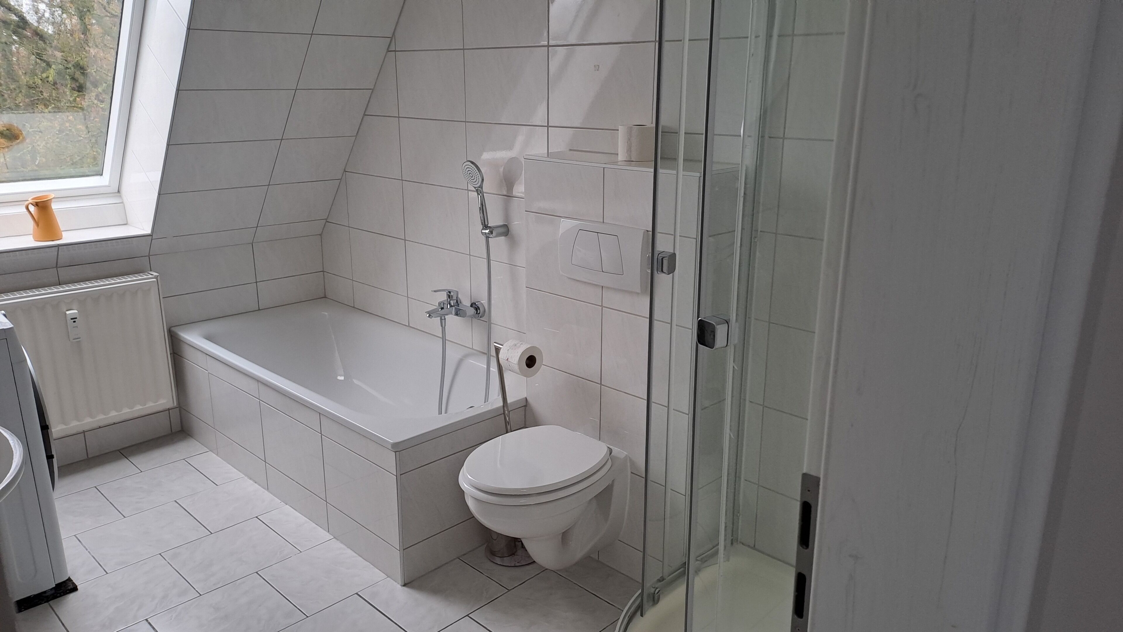 Un bagno moderno con vasca, WC e cabina doccia in vetro.