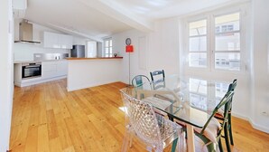Une cuisine moderne avec des meubles blancs, un four encastré et un plan de travail en bois.