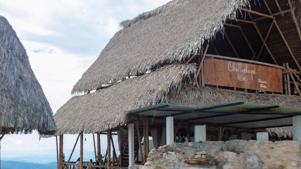 Un espace piscine agrémenté de structures à toits de chaume et d’une pancarte indiquant : « Chullahagni Wosi ».