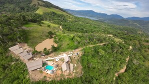 Un paysage rural avec une petite maison, une piscine et un chemin de terre.