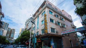 Un edificio de varios pisos con un letrero que indica un negocio o establecimiento de servicios en la planta baja.