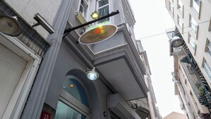 A building with a sign for 'AdaHome's Hotel' and a visible window with a red sign indicating room number 13. - Ilyada Hotel (Istanbul)