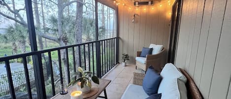Relax in this serene outdoor seating area with a wicker sofa and small table.