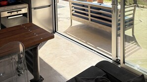 A modern kitchen with a large window, a dining table, and a view of a pool and garden. - Magia 22- Place for the Soul (Kathikas)