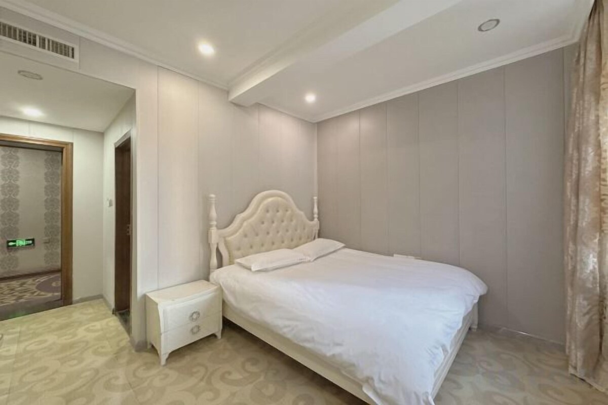 Un dormitorio con una cama individual, una mesita de noche y una puerta que da a otra habitación.