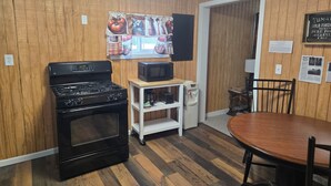 A compact kitchen with a stove, microwave, and a small shelf. - 2-bedroom country house in West Springfield, PA with WiFi, AC (West Springfield)