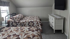 A bedroom with a bed, a dresser, a TV on the wall, and a window with blinds. - 2-bedroom country house in West Springfield, PA with WiFi, AC (West Springfield)