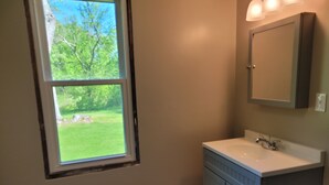 A bathroom with a window, a sink, and a cabinet. - 2-bedroom country house in West Springfield, PA with WiFi, AC (West Springfield)